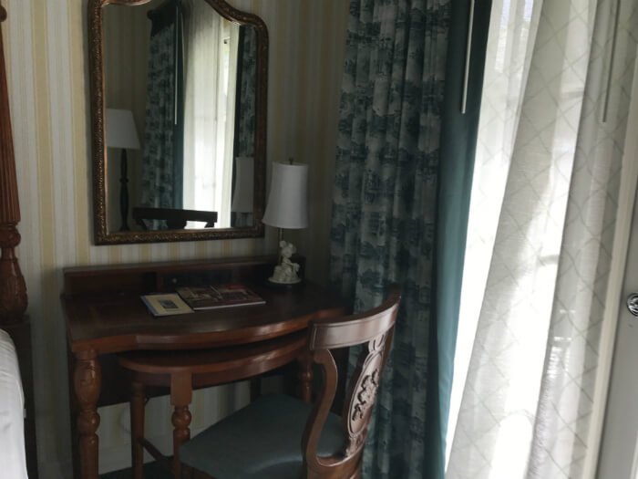 Picture of curtains, desk, mirror, lamp & bed at Disney's Boardwalk Inn