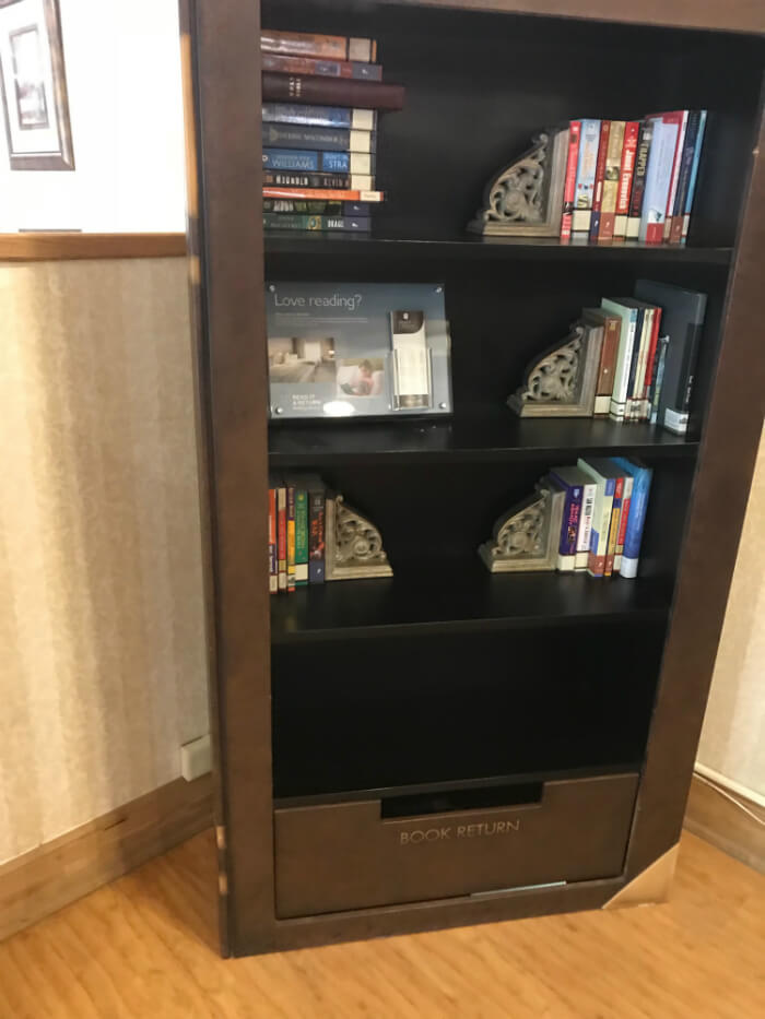 bookshelf with lending library in lobby of Country Inn & Suites Williamsburg East Busch Gardens