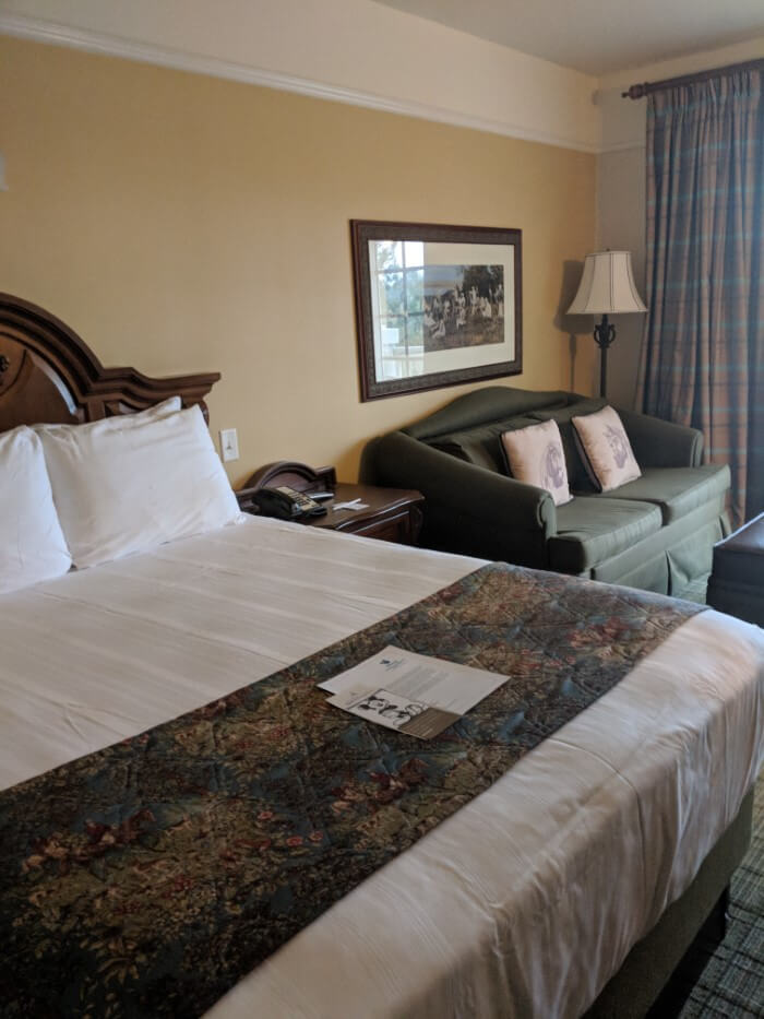 queen bed & sofa in Saratoga Springs hotel room at Disney World