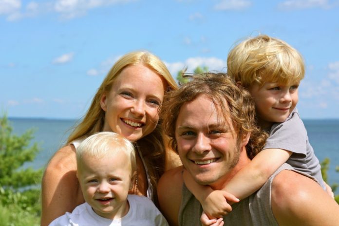 Picture of a happy family near a lake in Minnesota. Find out where to stay in Minnesota for a family vacation.