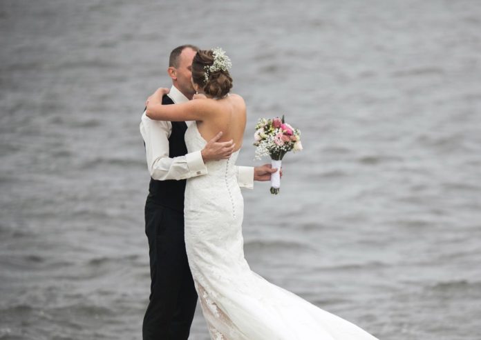 Best wedding venues in Ohio. Picture of a groom & bride kissing by a lake.