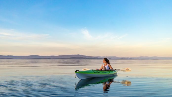 A picture of a woman kayaking at Qualicum Beach on Vancouver Island in British Columbia. Find out the area's best hotels