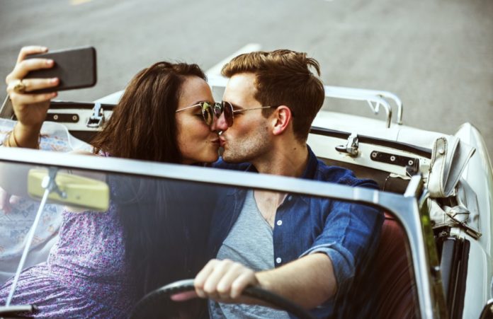 Couple Driving a Car Traveling on Road Trip Together. Learn how to get a free road trip.