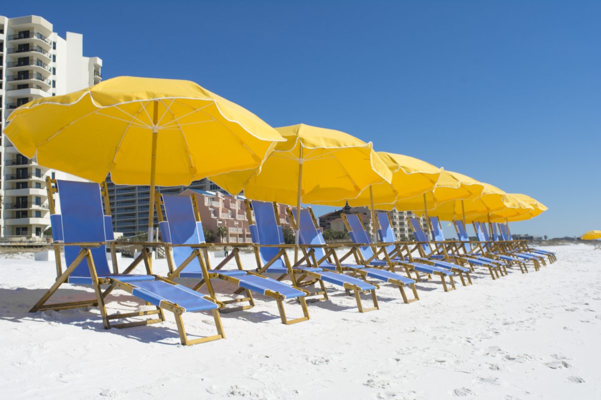 Relax on the beach under an umbrella when staying at Hilton Sandestin Beach Golf Resort & Spa